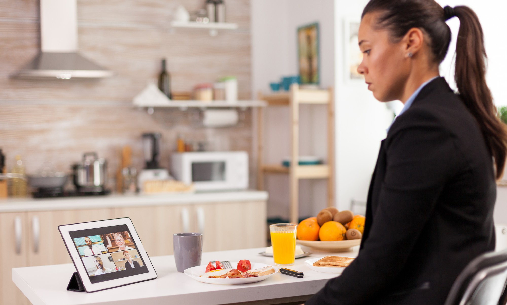 Instructor in kitchen workspace, teaching via laptop