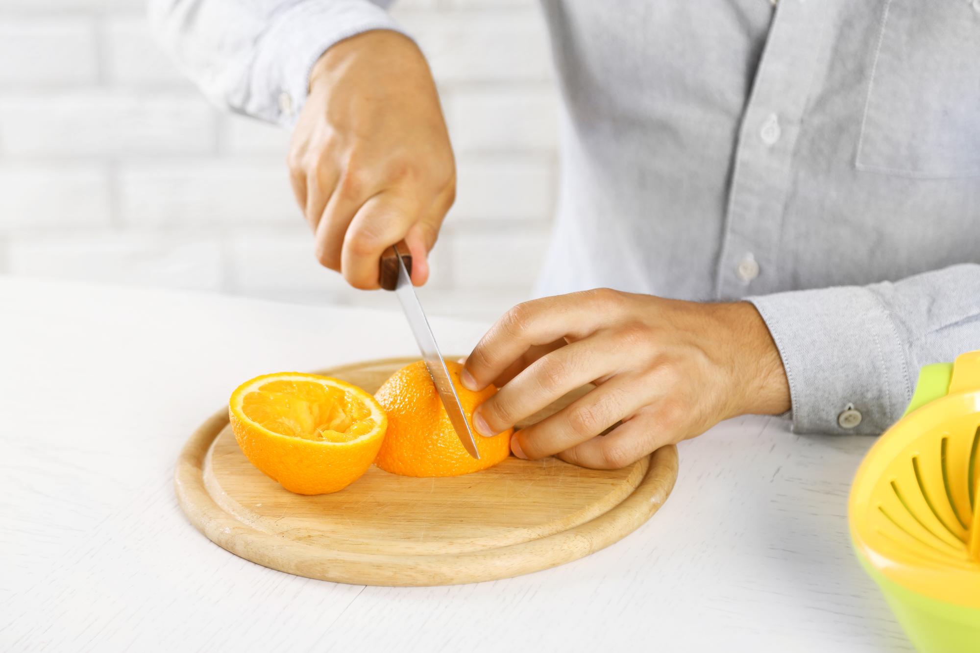 Hands slicing citrus for gremolata